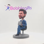 Boss masculin travaillant avec un bobblehead personnalisé de l'ordinateur